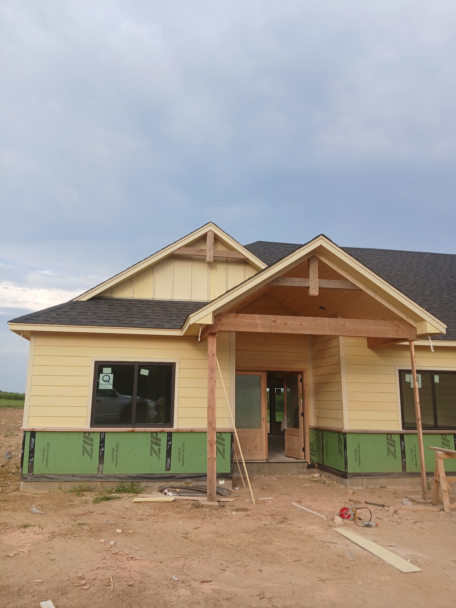 Residential home with siding, a shingle roof, and a timber entry porch