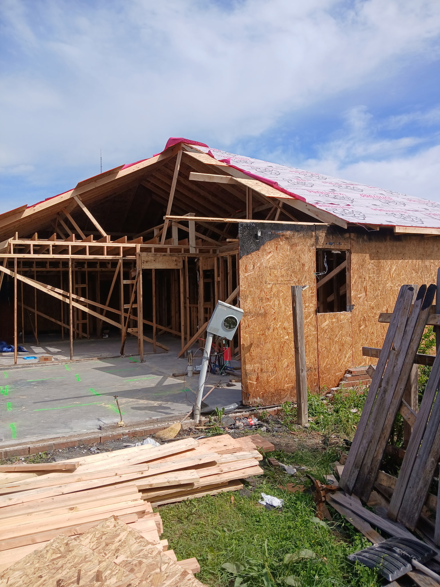 House opened up during a residential rebuild, with the roof sheathing and wall framing exposed