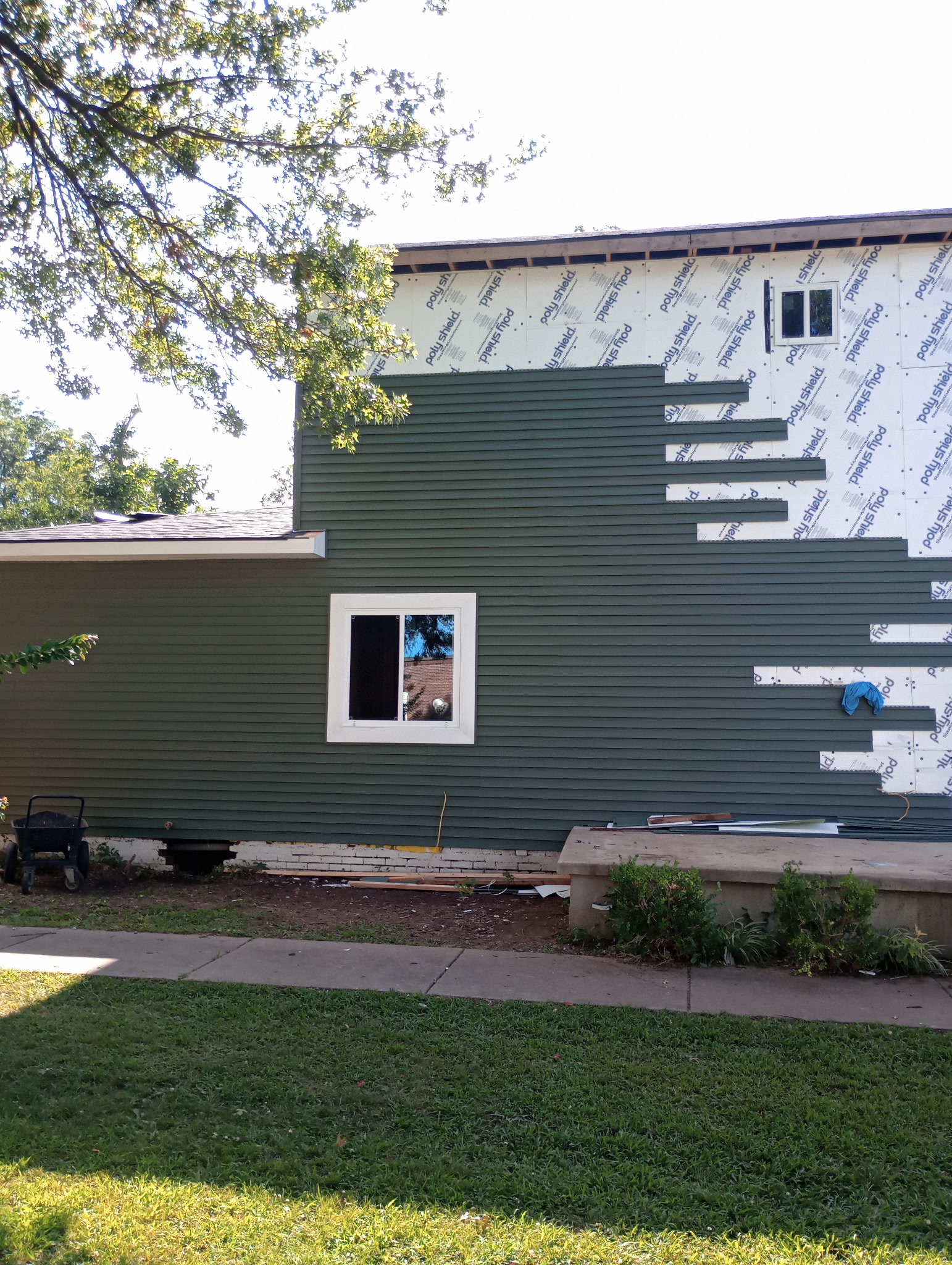 House exterior with new siding installed over part of the wall during a remodel