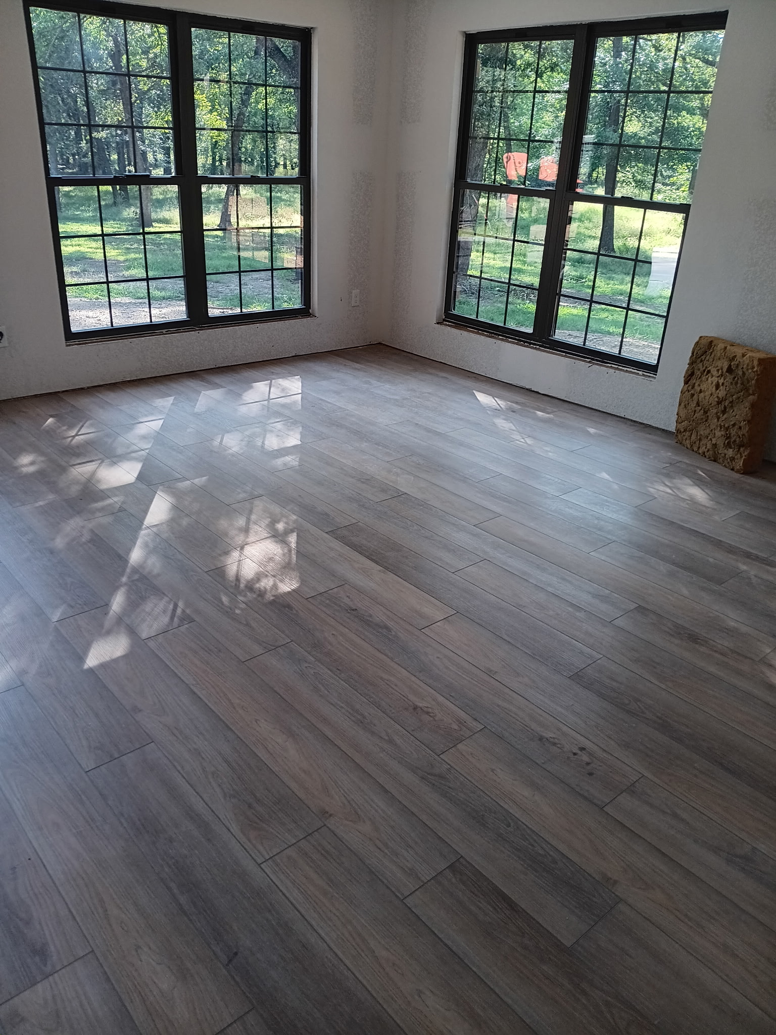 Light wood-look floor in a room with large black-framed windows